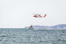 Helicopter makes multiple approaches toward Coast Guard cutter.