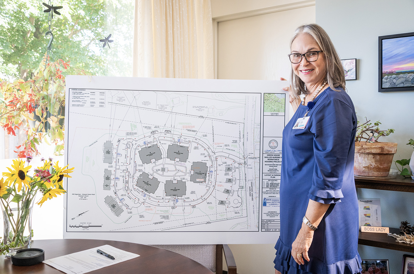 Denise Schepici, the president and COO of Martha's Vineyard Hospital, displays architectural drawing of Navigator Homes.