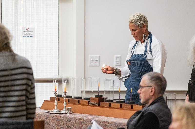 Chef Ting lights the first candle on the menorah.