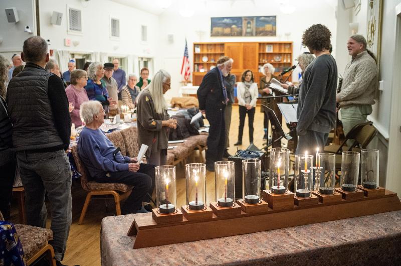 MV Hebrew Center congregation stands behind menorah.