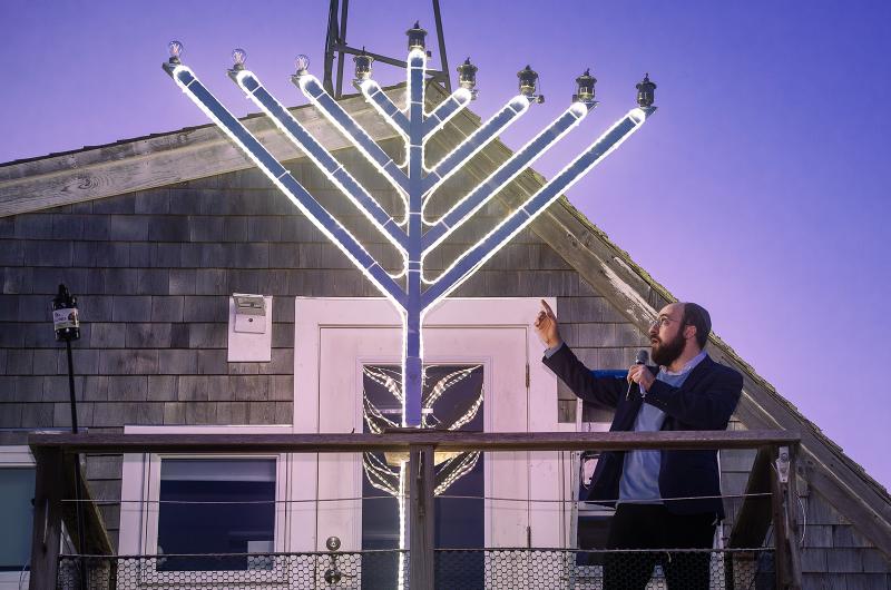 Rabbi Tzvi Alperowitz of Chabad on The Vineyard lights the menorah in Owen Park.